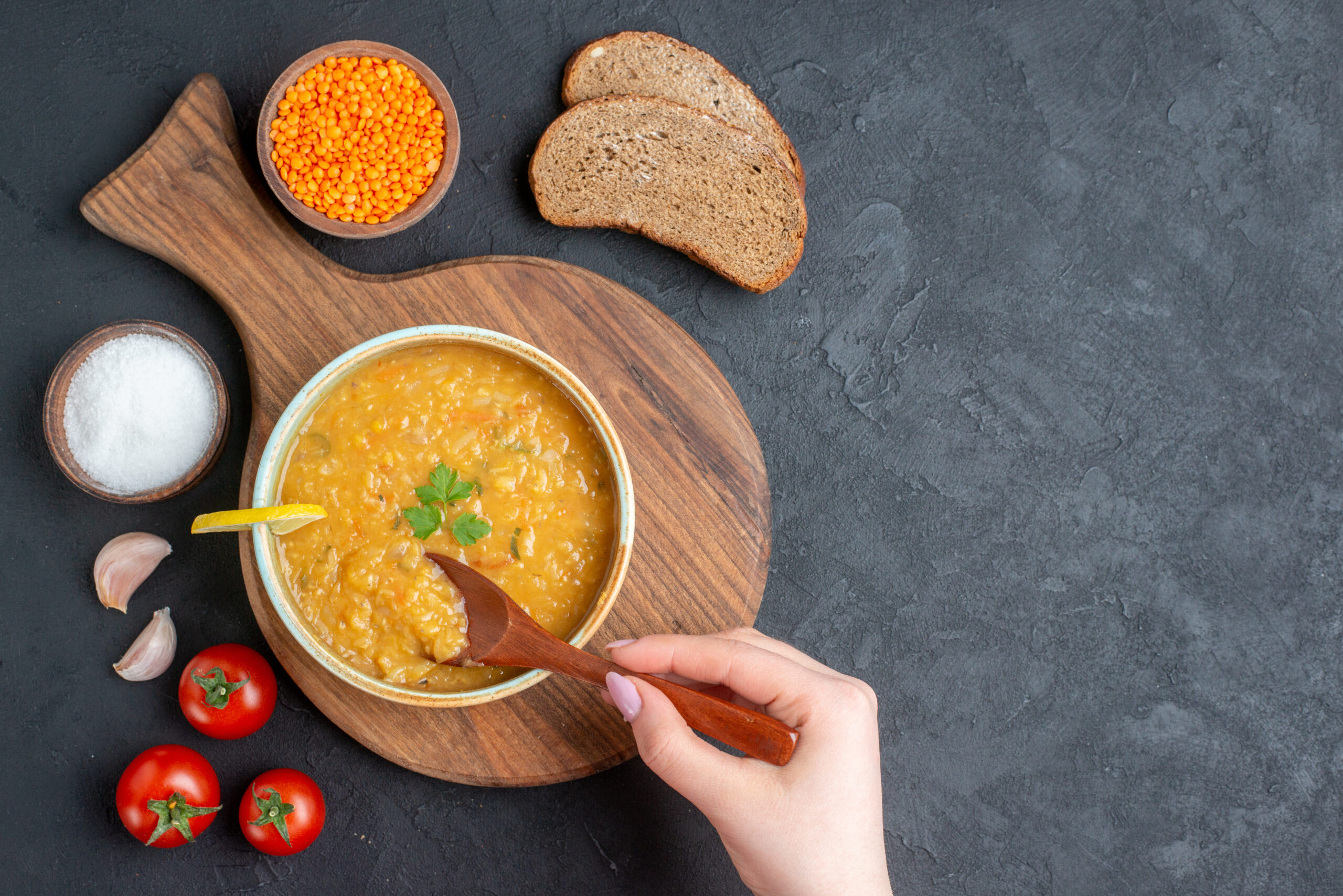 top-view-lentil-soup-with-salt-tomatoes-dark-bread-loaves-dark-surface